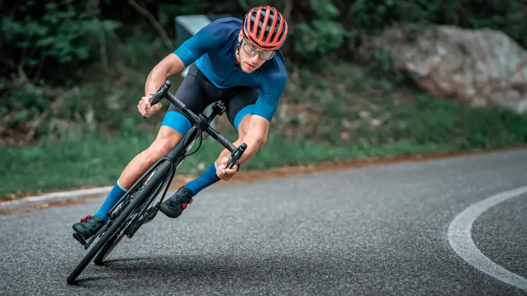 自転車を左に傾けてコーナリングをする人